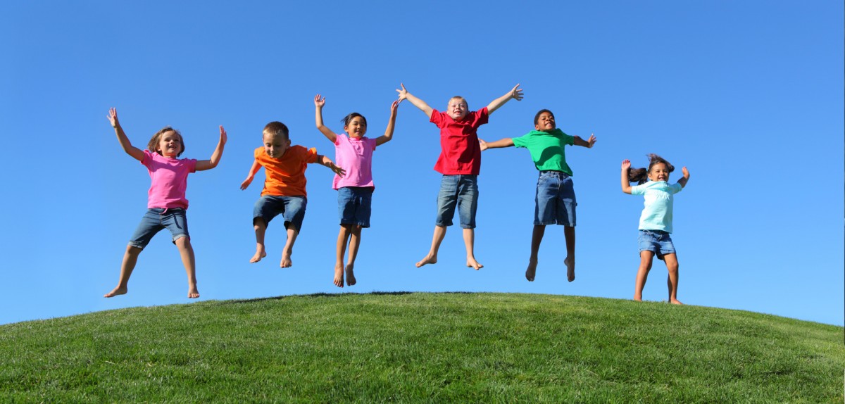 Dairy Products for All Lifestages - Six children joyfully jumping on a grassy hill under a bright blue sky, wearing colorful shirts and shorts. The image is branded with the 'ABLE-KIDS' logo at the bottom, symbolizing Able Dairies' commitment to producing wellness and nutrition-focused dairy products for children's healthy growth and well-being.